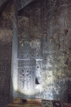 Dark church interior with carved cross and ornaments on the wall illuminated by soft light,