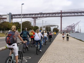 Cyclists on Ponte 25 de Abril, 3.2 km long bridge in Portugal with a 2278 meter long suspension