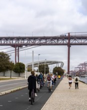 Cyclists on Ponte 25 de Abril, 3.2 km long bridge in Portugal with a 2278 meter long suspension