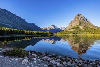 240831_066 Rippled reflection of the mountains on the calm waters of Lake Josephine in Glacier