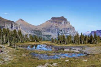 240905_111 Mountains colored by minerals rise up behind a pond along the Hidden Lake Overlook Trail