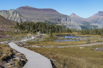 240905_108 Mountains colored by minerals rise up behind a pond along the Hidden Lake Trail from the
