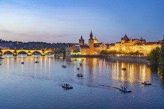 Vltava embankment with Old Town Water Tower, Novotný Bridge and Charles Bridge at dusk, Prague,