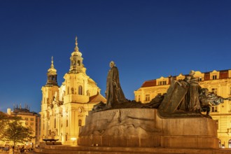 The Baroque St. Nicholas Church and the Jan Hus Memorial on Old Town Square at dusk, Prague, Czech