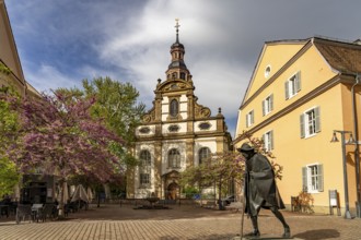 Sculpture of a Saint James Pilgrim on Maximilianstraße and the Trinity Church in Speyer,