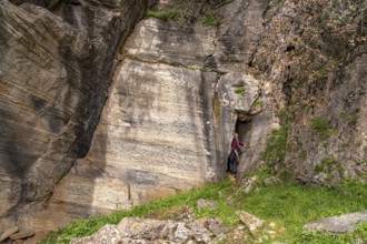 Tourist in the quarry near the prehistoric Palli-Lakka dragon houses Drakospita near Styra, island