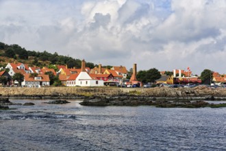 Many old half-timbered houses with red tiled roofs, fish smokehouse chimneys, picturesque port town