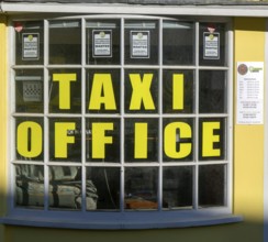 Taxi Office sign in window of booking office Devizes, Wiltshire, England, UK