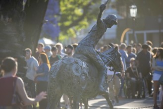 Metal sculpture of a polo player on the grounds of the polo stadium with many visitors, Buenos