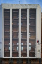 Construction work, renovation behind scaffolding tarpaulin, Buck weather protection tarpaulin,