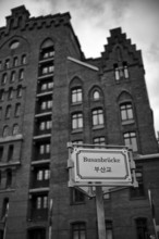 Busan Bridge sign, behind it Peter Tamm International Maritime Museum, warehouses, brick buildings,