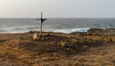 Religious scene, temporary Christian cross on the coast Farol de Cabo Raso lighthouse, São Bras de