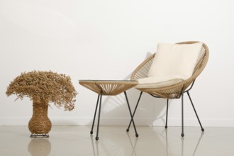 A cozy chair with soft cushioning sits next to a small, stylish table in a contemporary living area