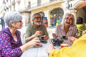 Happy senior friends gathering at an outdoor cafe, drinking coffee, and having a lively