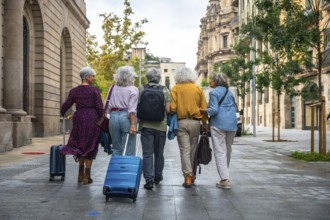 Group of diverse senior women friends enjoying city travel together, walking on an urban street