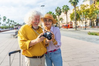 Happy senior couple exploring a sunny european city, smiling as they review photos on a vintage