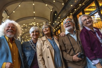 Group of happy senior friends smiling while walking together in a city street at night,