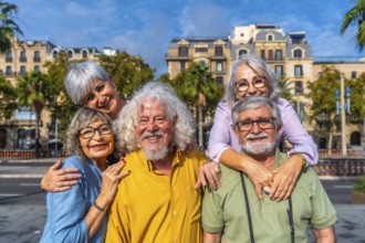 Smiling group of senior friends enjoying carefree retirement travel together in a sunny european
