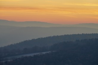 Gentle hills in fog at a warm sunset create a peaceful natural landscape, Seckmauern, Lützelbach,