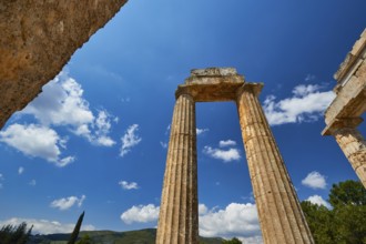 Massive ancient pillars rise against a bright blue sky, Nemea, Ancient Zeus Church, Archaeological