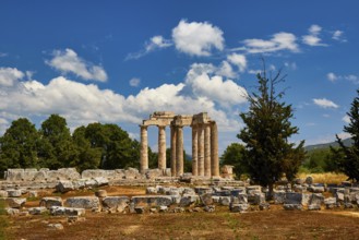 Stone ruins and ancient pillars against a cloudy blue sky, Nemea, Ancient Zeus Church,