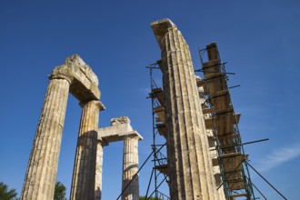 Old pillars with scaffolding, clear sky. Greek Ruins, Nemea, Ancient Zeus Heightum, Archaeological