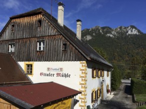 View of side view of Gasthof Ettaler Mühle in a historic two-storey baroque half-hipped roof dating