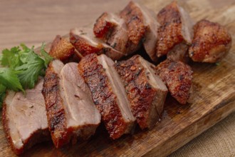 Roast duck breast, sliced, on a wooden chopping board, close-up, no people