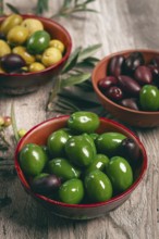A mixture of olives, varieties of chalkidiki, Verdi giganti and Kalamata, in a bowl, top view, no