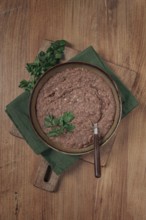 Red bean lobio, a traditional Georgian dish, on a wooden table, homemade