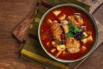 Souzi soup. Georgian dish, meat with oats, tomato sauce and herbs, on a wooden table
