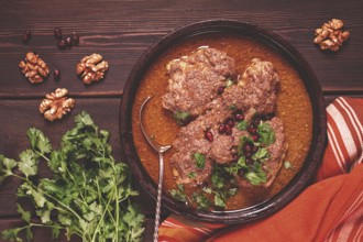 Fesenjan, an Iranian dish, stewed chicken, in walnut-pomegranate sauce, in an earthen pan,