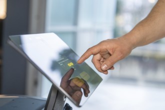 Close-up of a hand interacting with a touchscreen in a modern setting, robotic personality