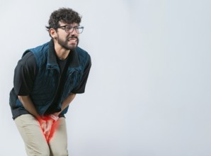 Person with medical problem urinary. Male with hands on crotch with urinary problems. Young woman