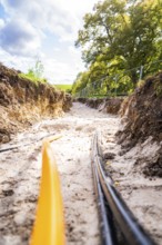View of a ditch with cables during construction under sunny skies, PV Freifaechenanlage