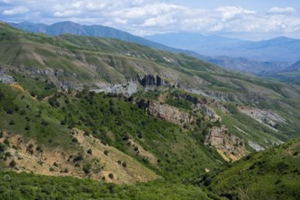 Rocks and green hills stretch under a blue sky, rocky landscape, landscape from the south towards
