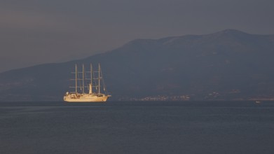 A large sailing ship sails in calm seas against a mountain backdrop at dusk, Nauplion, Nafplion,