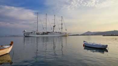Port of Nauplion, A large sailing ship is lying in a calm sea, surrounded by smaller boats, under a
