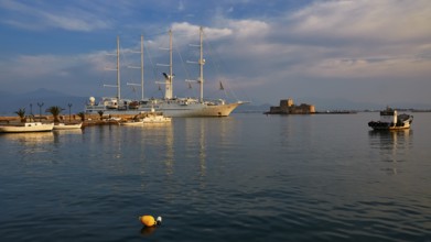 Bourtzi island fortress, port of Nauplion, A large sailing ship in the harbor with calm water and a