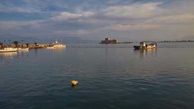 Bourtzi island fortress, port of Nauplion, A quiet harbor with boats and a small fortress under a