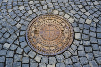 Round metal manhole cover on paved ground with interesting structure, manhole cover, Hünfeld,