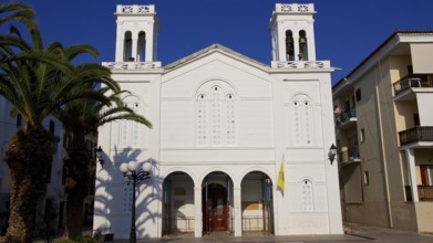 Old town of Nauplion, white church with palm trees in the foreground under clear sky, Nauplion,