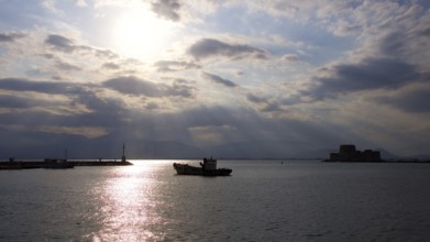 Nauplion harbour, Bourtzi island fortress, atmospheric picture with sunbeams over the water at