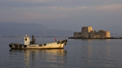 Port of Nauplion, Bourtzi island fortress, A small boat in front of a historic fortress in the calm