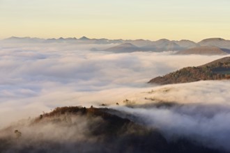 View from the Gisliflue of the Jurassic foothills covered in fog in the light of the rising sun,