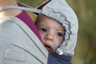 Baby, two months, in a towel on her mother's back, Othenstorf, Mecklenburg-Western Pomerania,