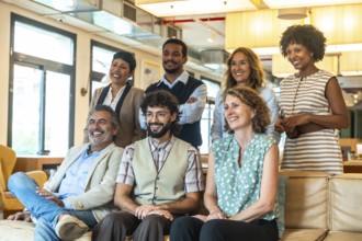 Diverse group of smiling coworkers in a modern coworking office, posing together to convey