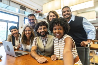 Diverse group of smiling colleagues collaborating and taking a cheerful selfie, reflecting