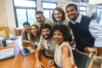 Diverse and inclusive business team smiling together during a casual meeting in a modern coworking