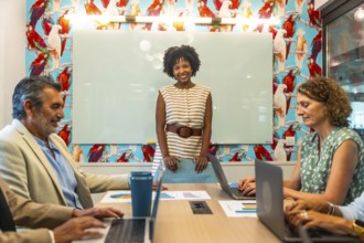Diverse business team collaborating in a vibrant coworking space, discussing data charts and